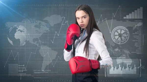 Young beautiful woman dress in white shirt standing in combat pose with red boxing gloves. Business concept.