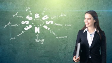 Kadın takım elbise holding evrak çantası üzerinde çizilmiş bir iş fikir kroki ile duvarının yakınında. Başarılı bir iş kavramı.