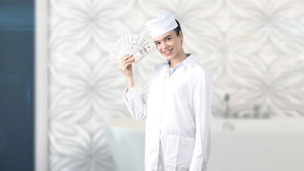 Bella dottoressa in uniforme. Studio dipinto sfondo. Concetto di assistenza sanitaria redditizia . — Foto Stock