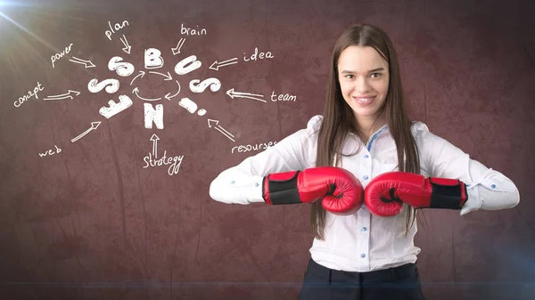 Kırmızı boks eldivenleri üzerine çizilmiş bir iş fikir kroki ile duvara yakın duran bir kadın. Başarılı bir iş kavramı. — Stok fotoğraf