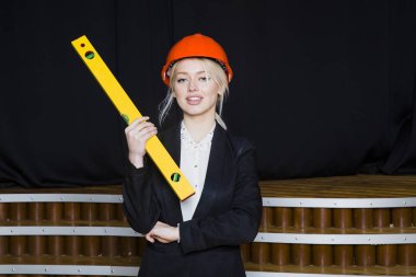 Uygulama katmanı loft Bürosu'nda portakal inşaat kask ve takım elbise ile güzel sarışın işkadını.