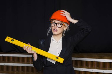 Uygulama katmanı loft Bürosu'nda portakal inşaat kask ve takım elbise ile güzel sarışın işkadını.