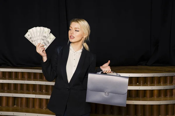 Mulher de negócios loira bonita com dinheiro no escritório loft em terno preto . — Fotografia de Stock