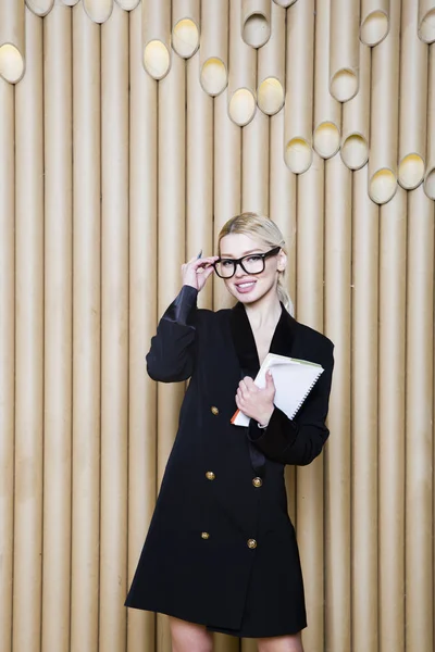 Hermosa mujer de negocios rubia sorprendida en vestido negro y gafas . — Foto de Stock