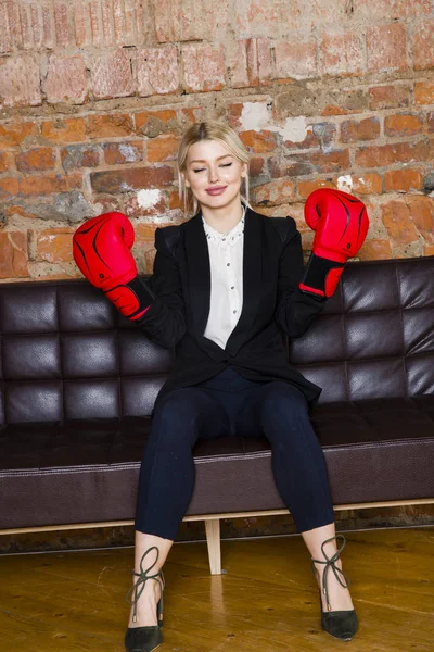 Ελκυστική ξανθιά επιχειρηματίας με γάντια του μποξ έτοιμος για έναν αγώνα μπροστά από ένα διαμέρισμα. Επιχειρηματική ιδέα. — Φωτογραφία Αρχείου