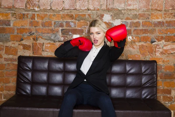 Attraktiv blond affärskvinna med boxning handskar redo för en kamp framför en lägenhet. Affärsidé. — Stockfoto