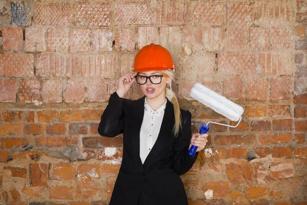 Mimar öğrenci veya rulo ile ressam portre ve miğfer korumak. Tuğla kırmızı arka plan.