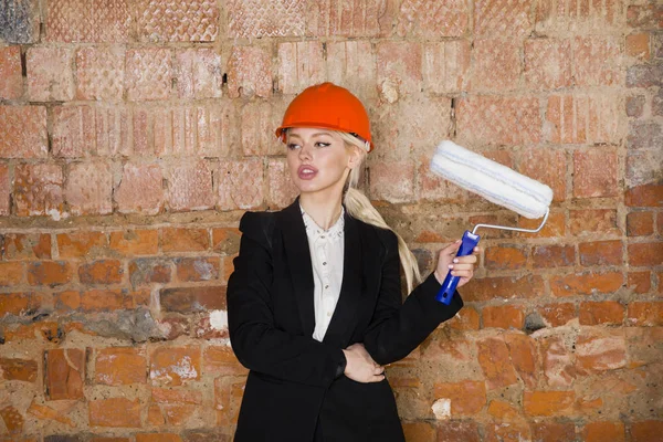 Mimar öğrenci veya rulo ile ressam portre ve miğfer korumak. Tuğla kırmızı arka plan.