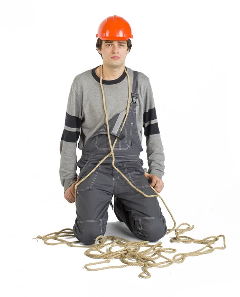 Een jonge werknemer in het grijs uniform vastgebonden met touw op witte geïsoleerde achtergrond. — Stockfoto