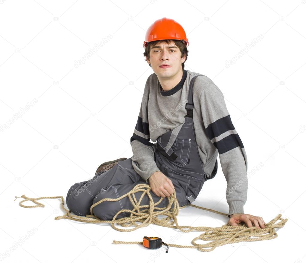 A young worker in grey uniform tied up with rope on white isolated background.