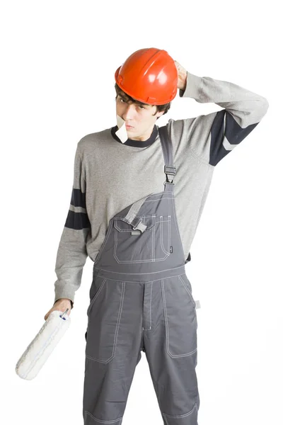 Un joven con ropa gris de trabajo y casco duro naranja con cinta adhesiva sobre la boca. Aislado sobre fondo blanco . — Foto de Stock