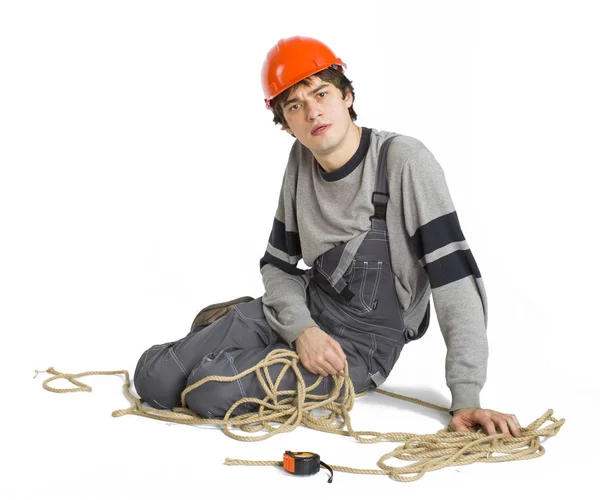 Een jonge werknemer in het grijs uniform vastgebonden met touw op witte geïsoleerde achtergrond. — Stockfoto