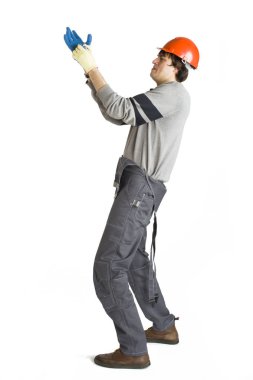 Gri ve beyaz izole arka planda bir eldiven koyarak turuncu zor kask işçi içinde genç bir adam.