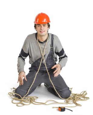 Gri üniformalı genç bir işçi beyaz izole arka planda iple bağladı.