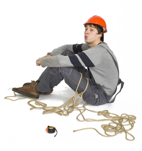 A young worker in grey uniform tied up with rope on white isolated background. — Stock Photo, Image