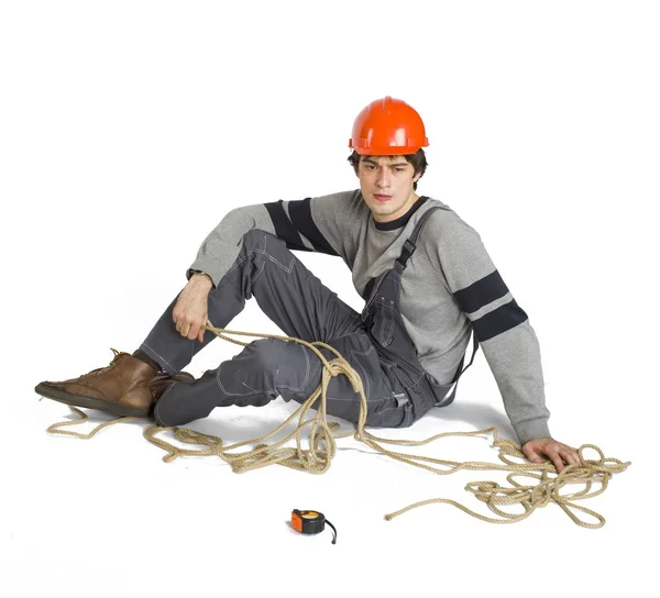 Een jonge werknemer in het grijs uniform vastgebonden met touw op witte geïsoleerde achtergrond. — Stockfoto