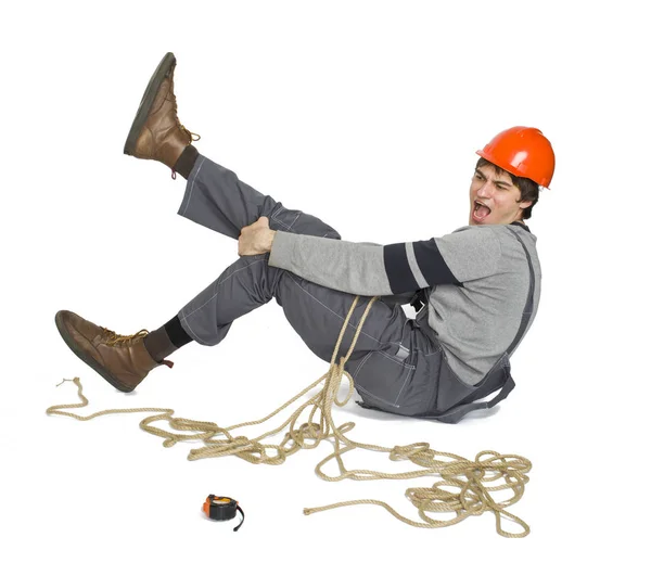 Un giovane operaio in uniforme grigia legato con corda su sfondo bianco isolato . — Foto Stock