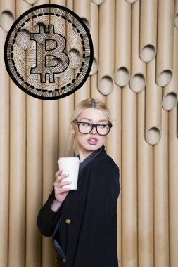Ayakta bitcoin kroki yakınındaki gösterilen güzel sarışın bir kadın. Sanal para veya btc ezmek kavramı. Cryptocurrency.
