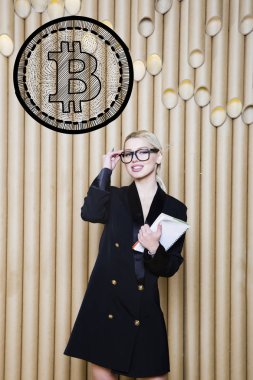 Ayakta bitcoin kroki yakınındaki gösterilen güzel sarışın bir kadın. Sanal para veya btc ezmek kavramı. Cryptocurrency.