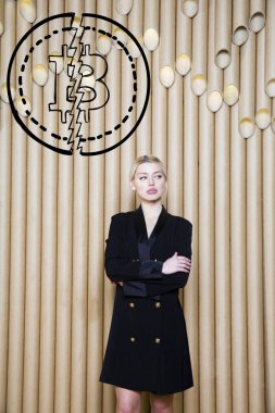 Ayakta bitcoin kroki yakınındaki gösterilen güzel sarışın bir kadın. Sanal para veya btc ezmek kavramı. Cryptocurrency.