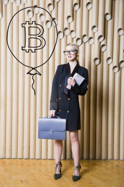 Ayakta bitcoin kroki yakınındaki gösterilen güzel sarışın bir kadın. Sanal para veya btc ezmek kavramı. Cryptocurrency.