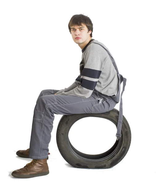 En ung brunet förman i arbetande grå uniform med svarta hjul. — Stockfoto