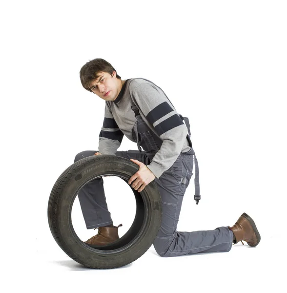 En ung brunet förman i arbetande grå uniform med svarta hjul. — Stockfoto