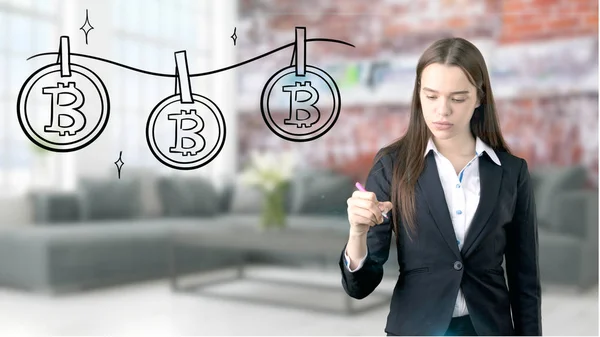Förvånad leende ung kvinna klädd i en kostym och tittar på en kryptovaluta skiss på en design plan vägg. Begreppet Bitcoin risk. — Stockfoto