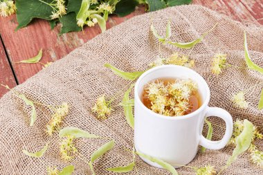 Linden çay bir fincan ahşap arka plan üzerinde.