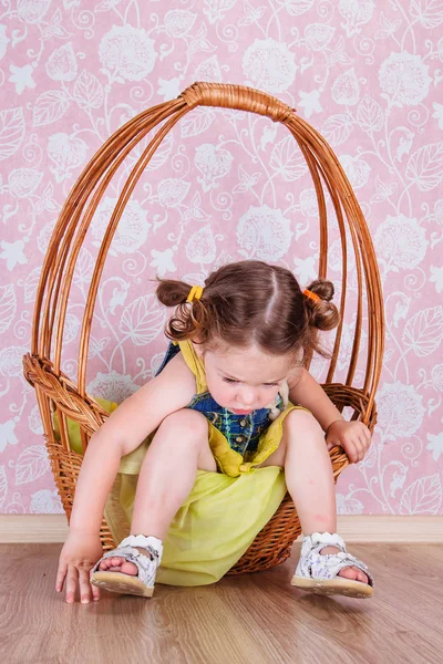 Girl sitting on a wicker basket Stock Picture