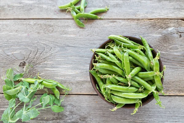 ahşap bir masa üzerinde bir kil plaka genç bezelye