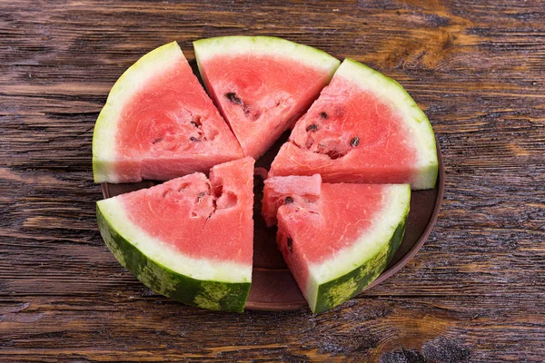 Tahta arka planda dilimlenmiş karpuz.
