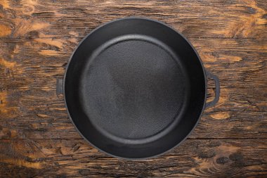 bir dökme demir tava ahşap arka plan üzerinde