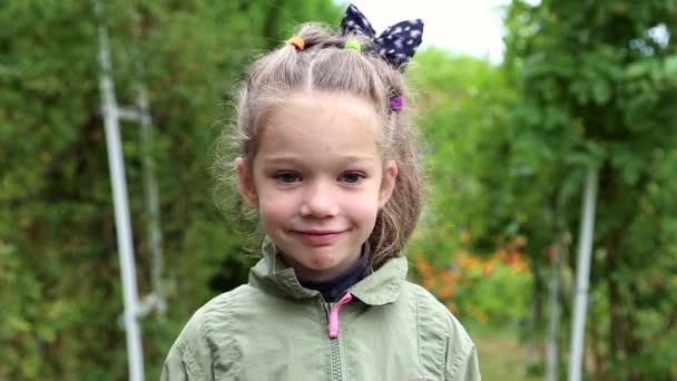 Beautiful little girl standing on a green background, portrait — Stock Video