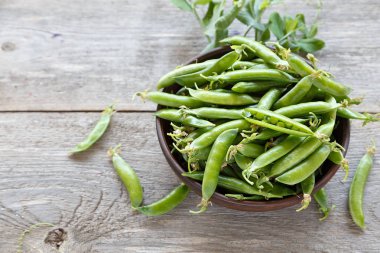 ahşap bir masa üzerinde bir kil plaka genç bezelye