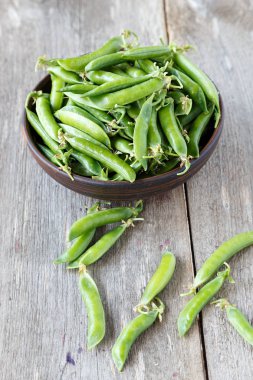 ahşap bir masa üzerinde bir kil plaka genç bezelye