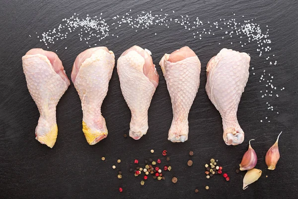 Jambes de poulet crues sur fond noir — Photo