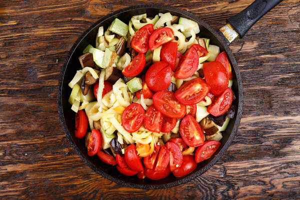 Sliced fresh vegetables in pan with spices