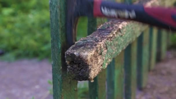 Carpinteiro com um martelo quebra cerca velha — Vídeo de Stock