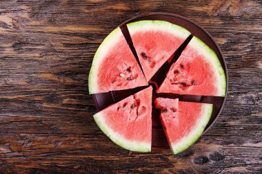 Tahta arka planda dilimlenmiş karpuz.
