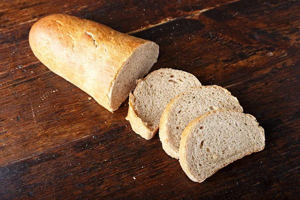 Нарезанный хлеб на деревянной текстуре — стоковое фото