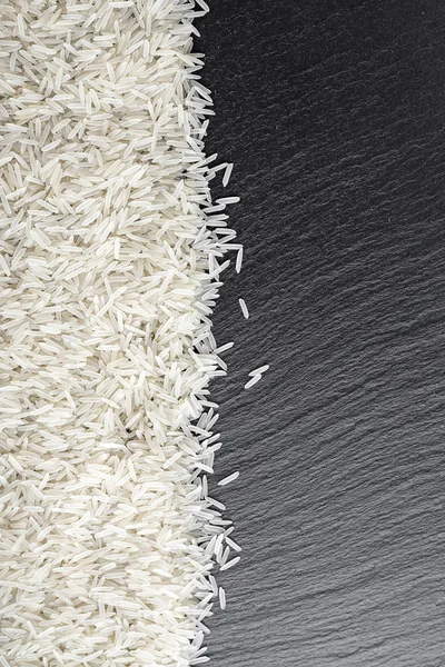 Рис, разбросанный на черном фоне — стоковое фото