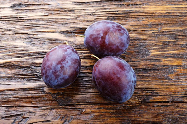 Ripe plums on a wooden background — Stock Photo, Image