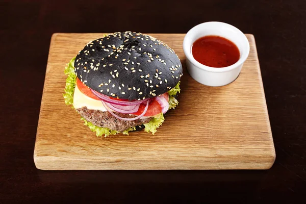 Černý burger na desce — Stock fotografie
