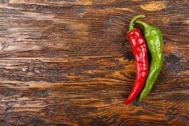 Ahşap arka plan üzerinde kırmızı ve yeşil acı biber