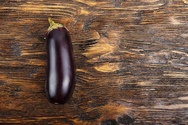 Eine Aubergine auf einem Holztisch — Stockfoto