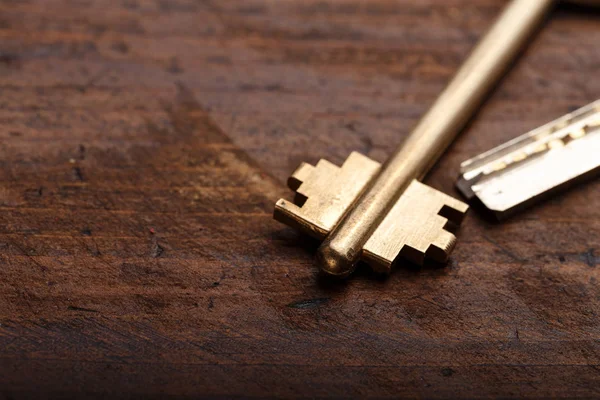 Una llave de la puerta sobre un fondo de madera — Foto de Stock