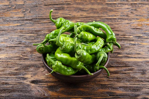 Hot green peppers in clay plate — Stock Photo, Image