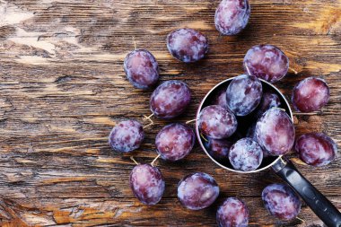 Olgun Erik kahverengi ahşap masa, sağlıklı gıda, yaz kırpma.