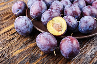 Olgun Erik kahverengi ahşap masa, sağlıklı gıda, yaz kırpma.